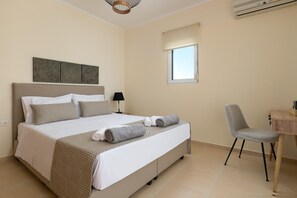 A hotel room with a bed, a desk, a chair, and a window. - Villa Olvia in Rhodes (Rhodes)