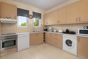 A modern kitchen with built-in appliances, including a dishwasher, washing machine, and microwave. - Villa Olvia in Rhodes (Rhodes)