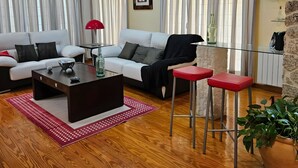 A living room with a sofa, a coffee table, a red lamp, and a potted plant.
