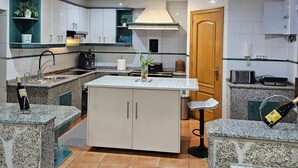 A modern kitchen with granite countertops, white cabinetry, and a central island.