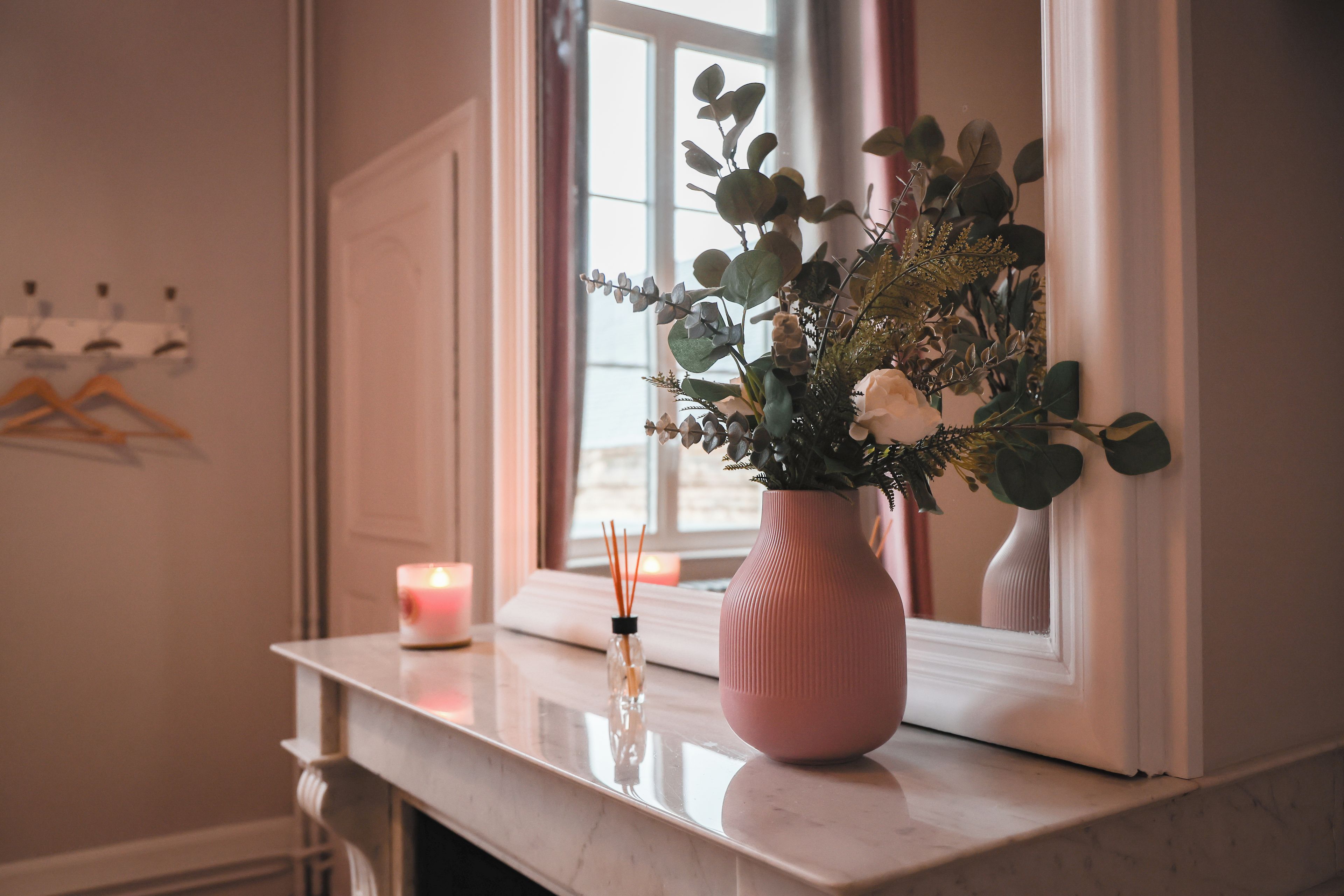 Eine Vase mit Blumen auf einem Fensterbrett.