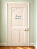 Una puerta blanca con el nombre 'Chambre Raphael' en letras cursivas.