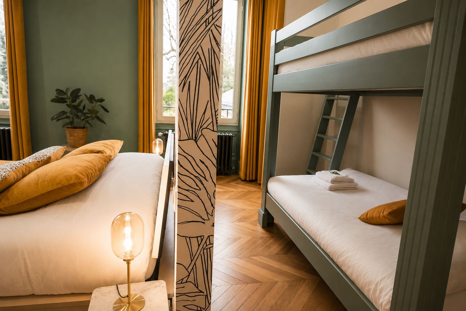 A bunk bed room with a bedside table, a lamp, and a potted plant.