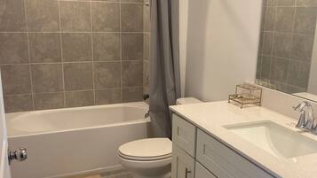 Un baño con bañera, inodoro y lavamanos.