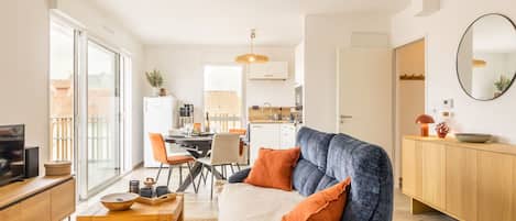 Una sala moderna con sofá, mesa de centro y comedor.