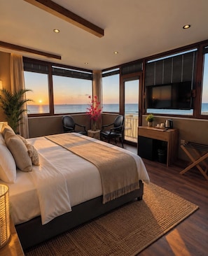 A bedroom with a large bed, a desk, and a view of the ocean. - Goga otel (Türkiye)