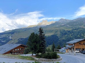 Ein Berglodge mit Blick auf ein Gebirge, ein Holzhaus und ein Parkplatz.