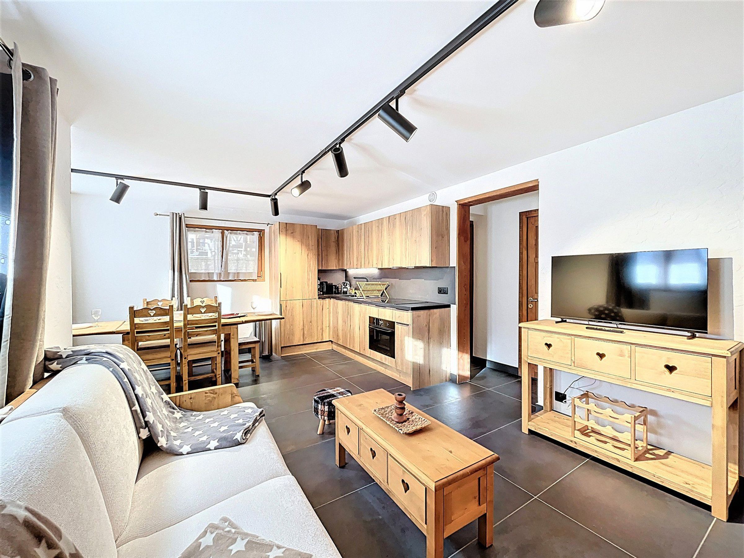 Un apartamento moderno con sala de estar, comedor, cocina y televisión.