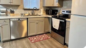 A kitchen with a dishwasher, microwave, stove, and refrigerator. - Cozy Home Away From Home (Woodbridge)