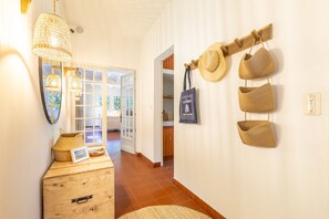 A hallway with a wooden chest, woven baskets, and a wall-mounted hat rack. - Villa Subera - à 2 min du lac d'Hossegor (Hossegor)