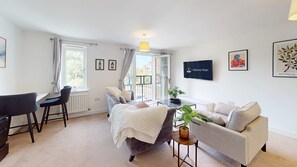 Et soveværelse med seng, sofa, skrivebord og fjernsyn.