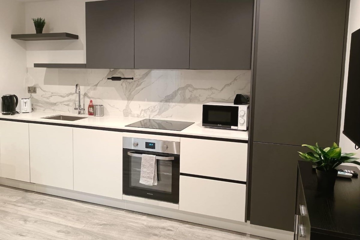 A modern kitchen with a built-in oven, microwave, and a coffee maker on the countertop.