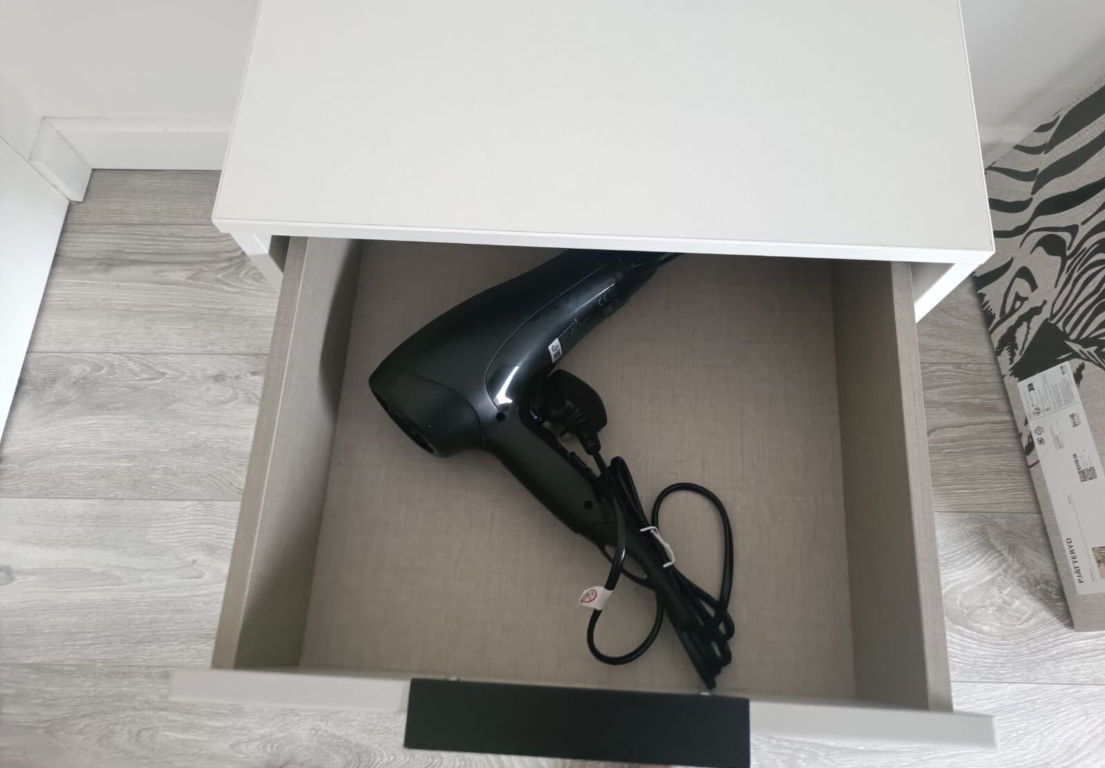 Gaveta com um secador de cabelo dentro.