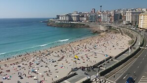 Una platja amb un paisatge urbà al fons.