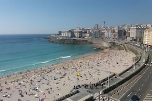 Ein Strand mit einer Stadtkulisse im Hintergrund.
