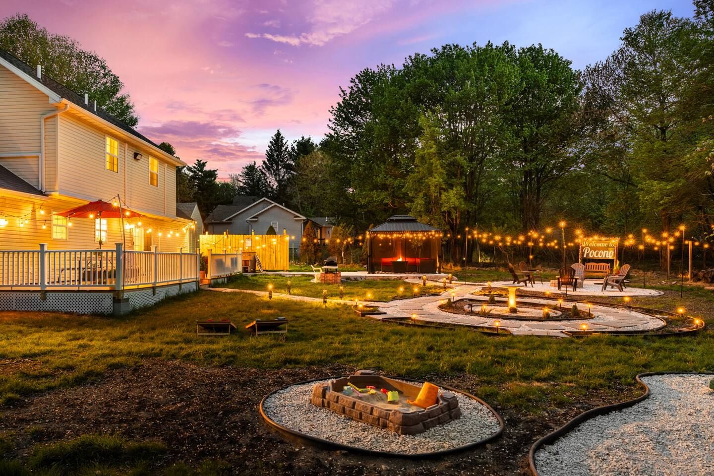 A residential property with a covered patio, outdoor seating area, and a fire pit.