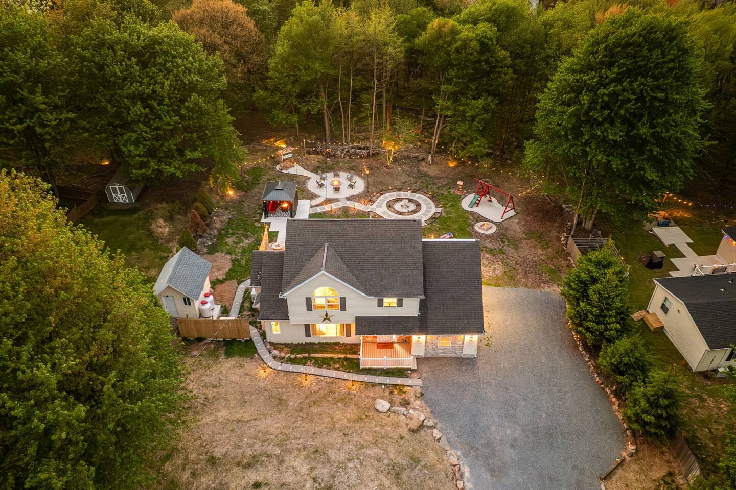A residential property with a central house, a fenced yard, and a circular outdoor seating area.
