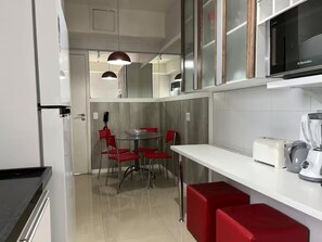 Eine moderne Küche mit Kühlschrank, Mikrowelle und Mixer auf der Arbeitsfläche.
