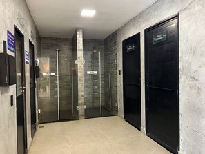 Ein Flur mit vier Türen, zwei beschriftet mit 'PUXE' und zwei mit 'TOILET FEMININO'.