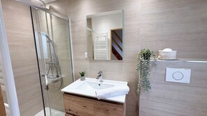 A modern bathroom with a glass shower enclosure, a wooden vanity, and a white sink. - Ilha Grande - Country House in the Somme Bay (Ponthoile)