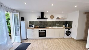A modern kitchen with a microwave, oven, and washing machine. - Ilha Grande - Country House in the Somme Bay (Ponthoile)