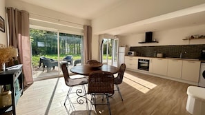 A modern kitchen with a dining area, large windows, and a view of the outdoors. - 2-bedroom apartment in Ponthoile (Ponthoile)