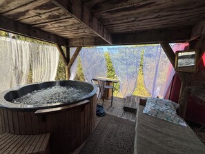 Una cabaña de madera con jacuzzi, una cama y una mesa.
