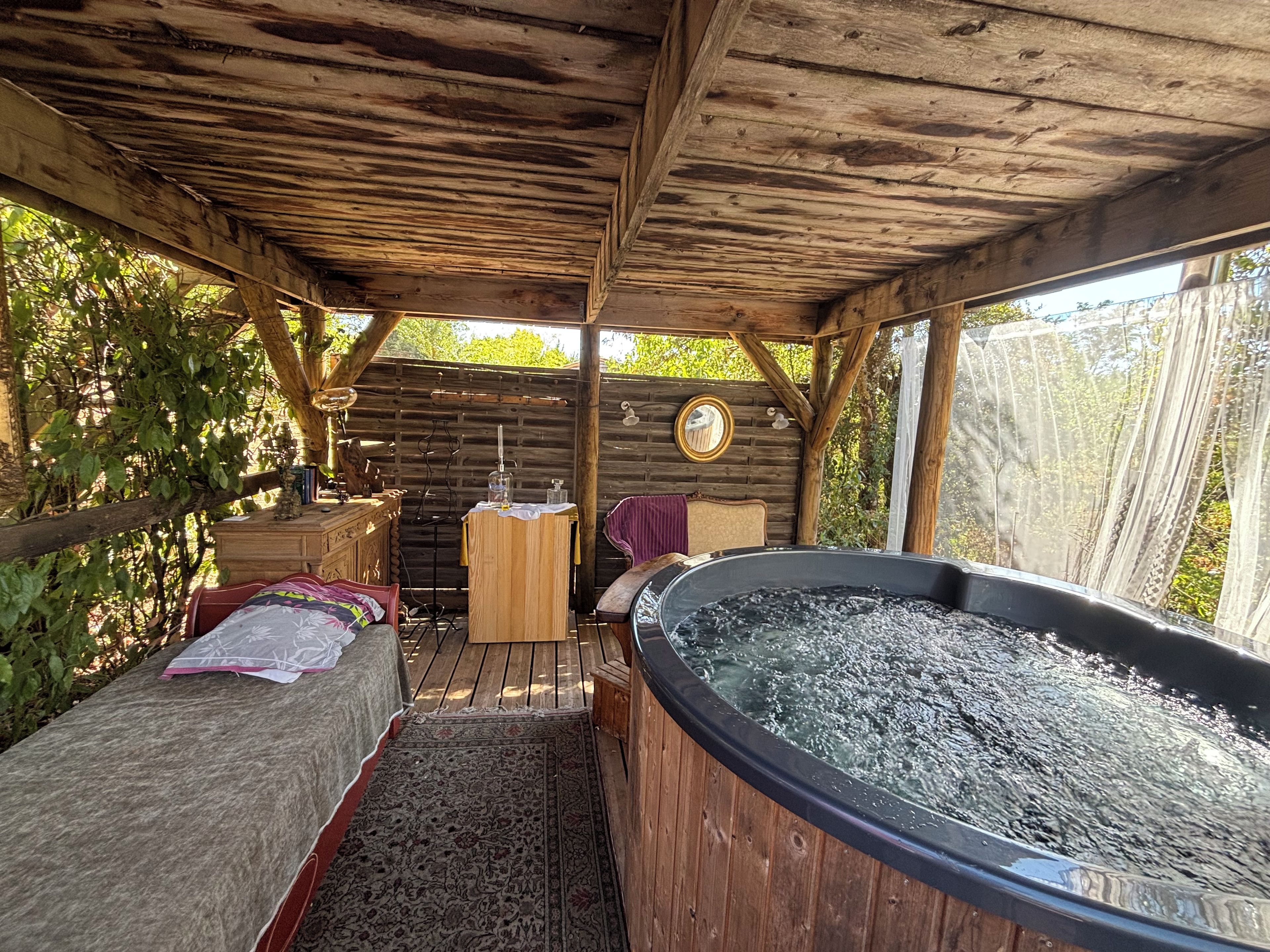 A rustic wooden cabin with a hot tub, a wooden dresser, and a mirror on the wall.