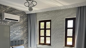 A modern bedroom with a bed, a radiator, and a window. - SUR-U ALA HOTEL (Diyarbakır)