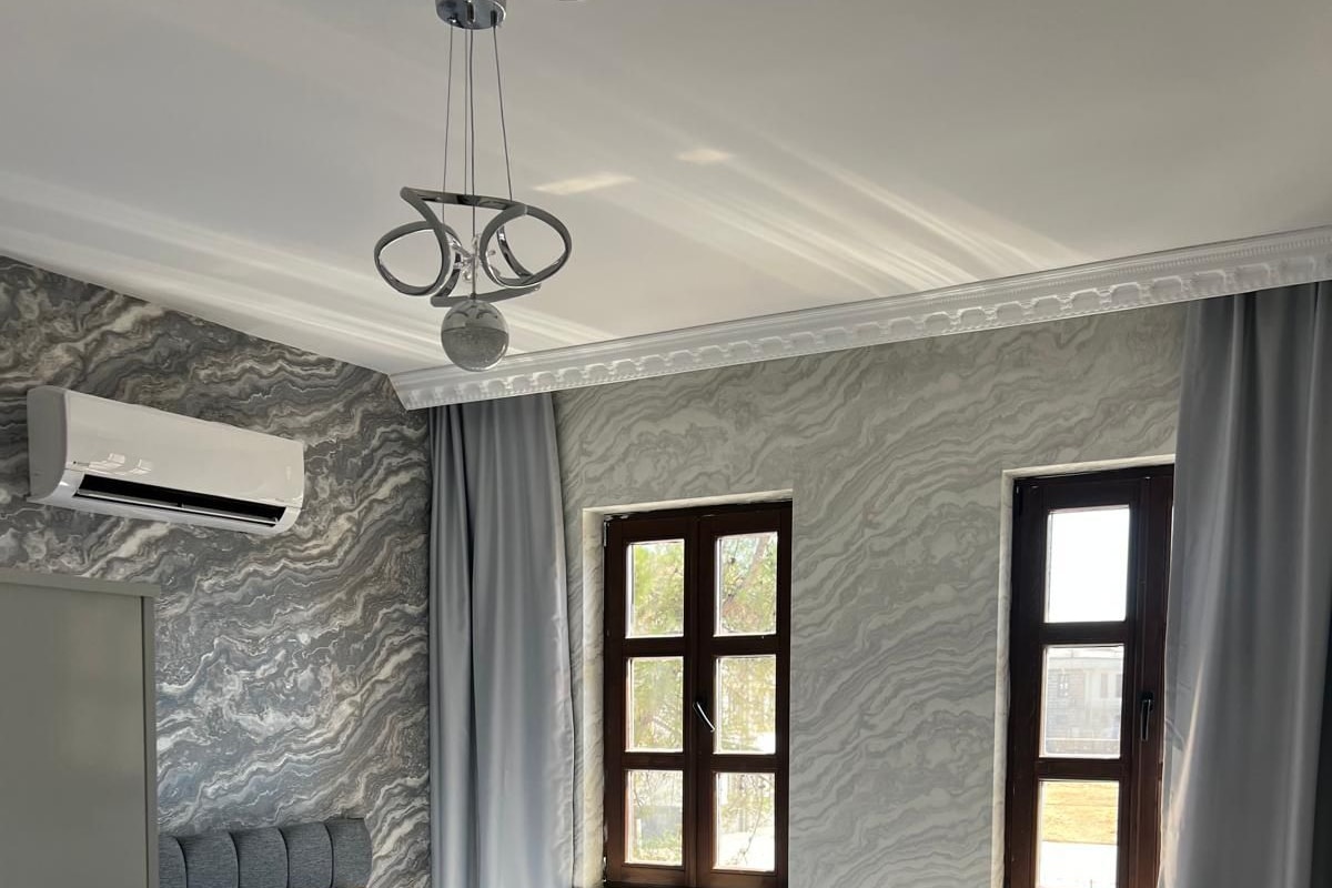Un dormitorio moderno con cama, radiador y ventana.