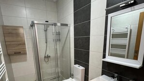 A modern bathroom with a glass-enclosed shower, a toilet, and a sink with a mirror above it. - SUR-U ALA HOTEL (Diyarbakır)