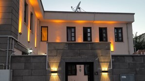 A building with a stone entrance, multiple windows, and a satellite dish on the roof. - SUR-U ALA HOTEL (Diyarbakır)