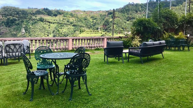 Un patio con mobiliario exterior, una mesa redonda y sillas.