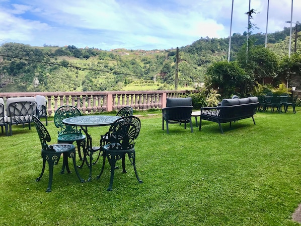 A patio with outdoor furniture, a round table, and chairs. - Vrbo Property (Santana)