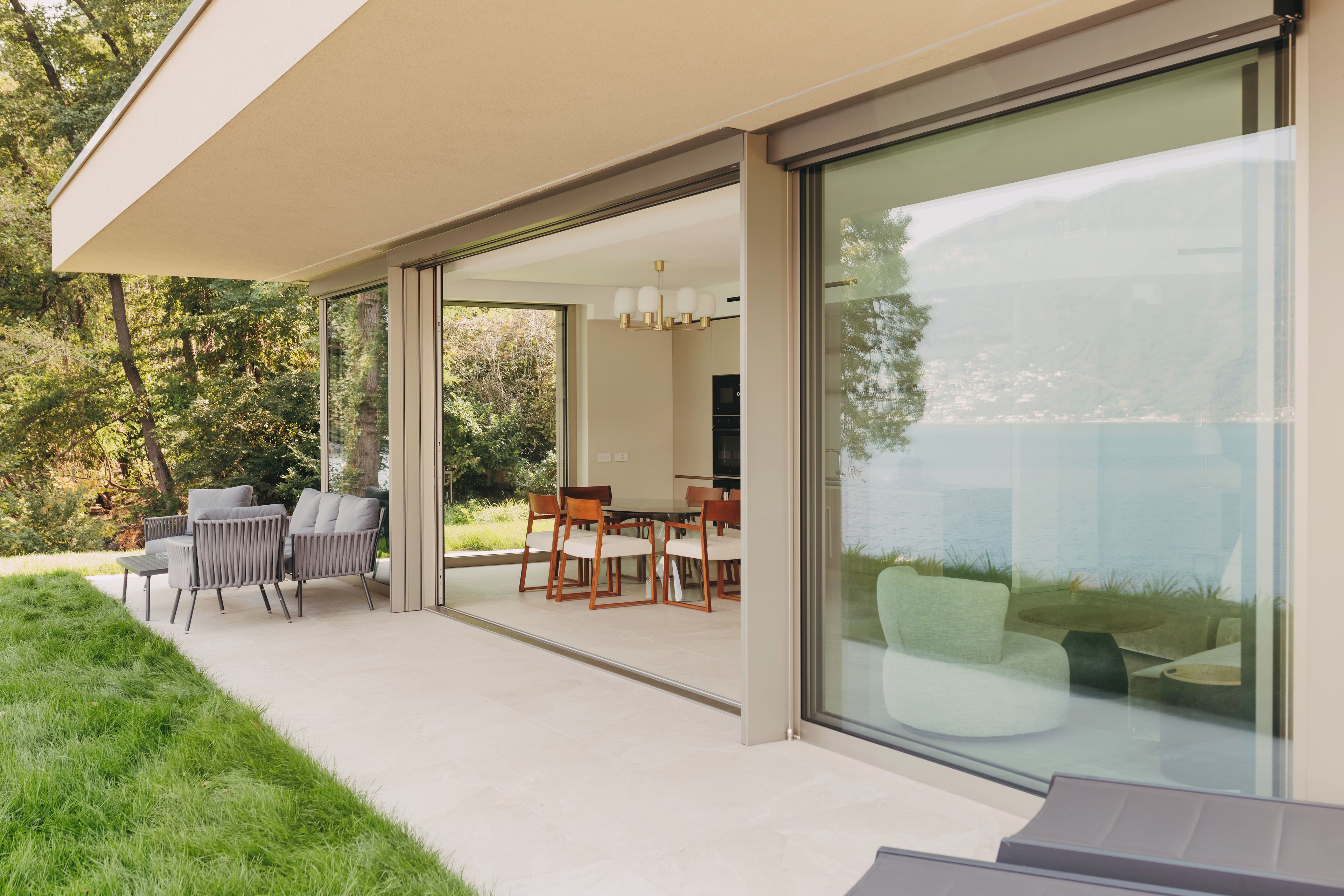 A modern outdoor patio with a dining area, chairs, and a table.