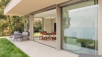 A modern outdoor patio with a dining area, chairs, and a table.