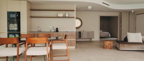 Un salon moderne comprenant un coin repas, une cuisine et une chambre.