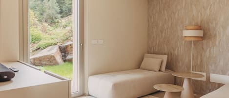 Una habitación moderna con un sofá, una mesa redonda pequeña y una lámpara.