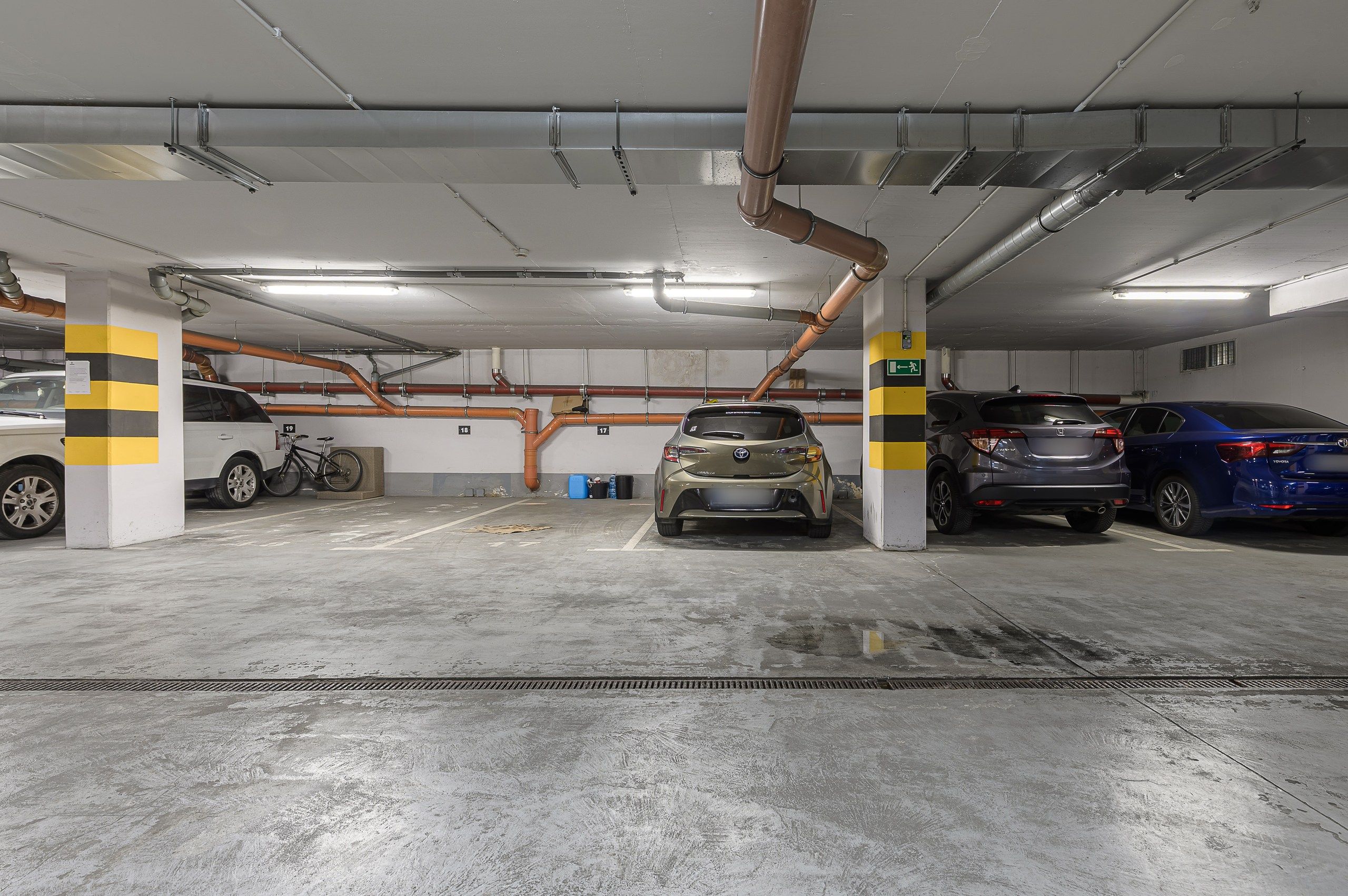 Een meerlaags parkeergarage met betonnen vloeren en gele streepzuilen.