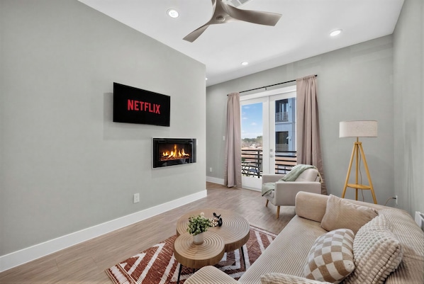 Cozy modern lounge with fireplace, Netflix, and private balcony views