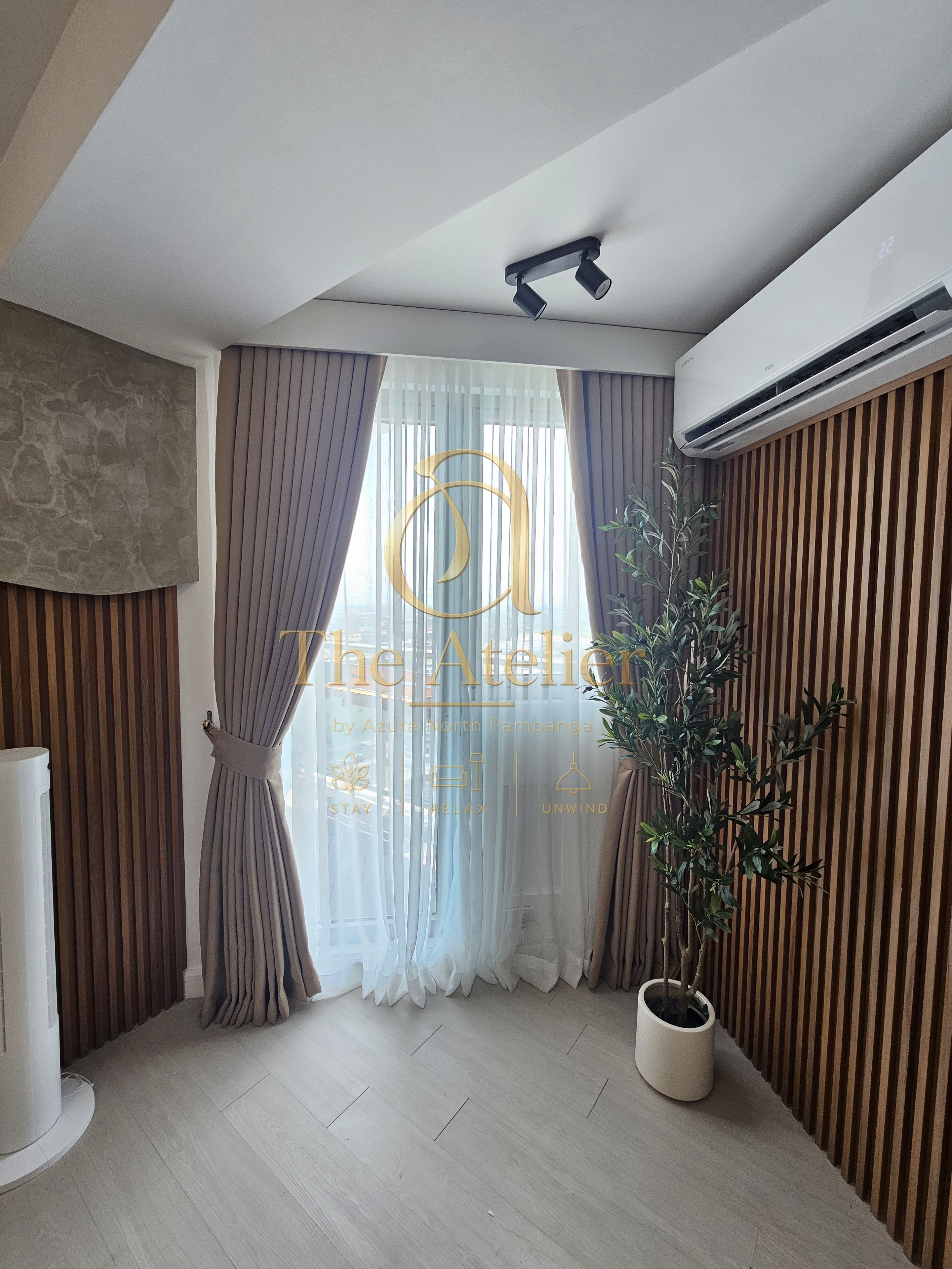 Une chambre moderne dotée d’une grande fenêtre, d’une plante en pot et d’un climatiseur fixé au plafond.