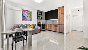 A modern kitchen with a built-in oven, a coffee machine, and a wooden cabinet. - Luxe Private Studio - Balcony & View (Bratislava III)