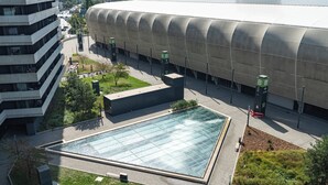 A modern building with a large glass atrium and a pool area. - Luxe Private Studio - Balcony & View (Bratislava III)