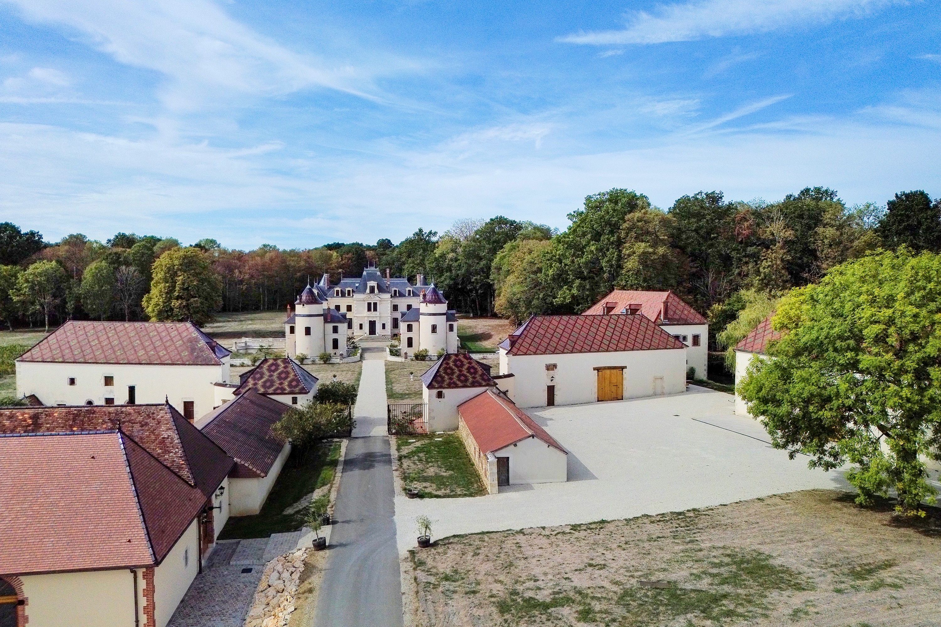 A courtyard with a central building, surrounded by smaller structures with red-tiled roofs.