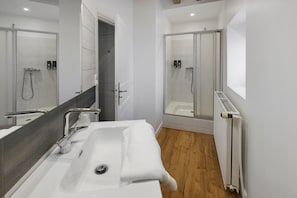Ein modernes Badezimmer mit einem großen Waschbecken, einer Dusche und einer Toilette.