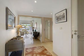 A hallway with a mirror, a desk with a lamp, a chair, and a door leading to another room. - Apartment '3 Pièces Cannes' with Shared Terrace, Wi-Fi and Air Conditioning (Cannes)