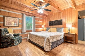 A wooden cabin bedroom with a bed, nightstands, a chair, and a ceiling fan. - Foliage Heaven! A+ Location! Cabin w/Private HTub (Sevierville)