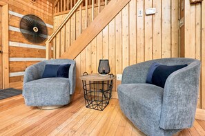 A wooden interior with two grey armchairs, a small round table, and a fan on the wall. - Foliage Heaven! A+ Location! Cabin w/Private HTub (Sevierville)