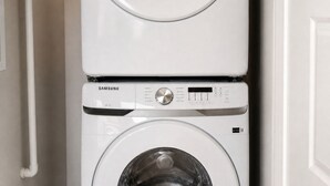Un appareil combiné lave-linge et sèche-linge, de type « empilable », doté de panneaux de commande et d’un code QR.