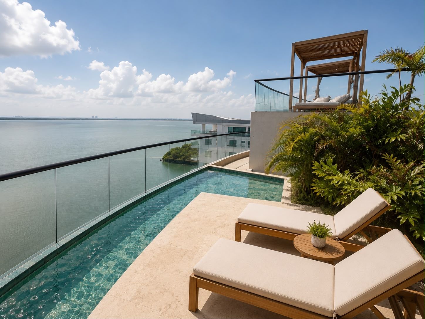Una piscina infinita moderna con agua cristalina, con vista a una masa de agua, con sillas de descanso y una pérgola de madera.